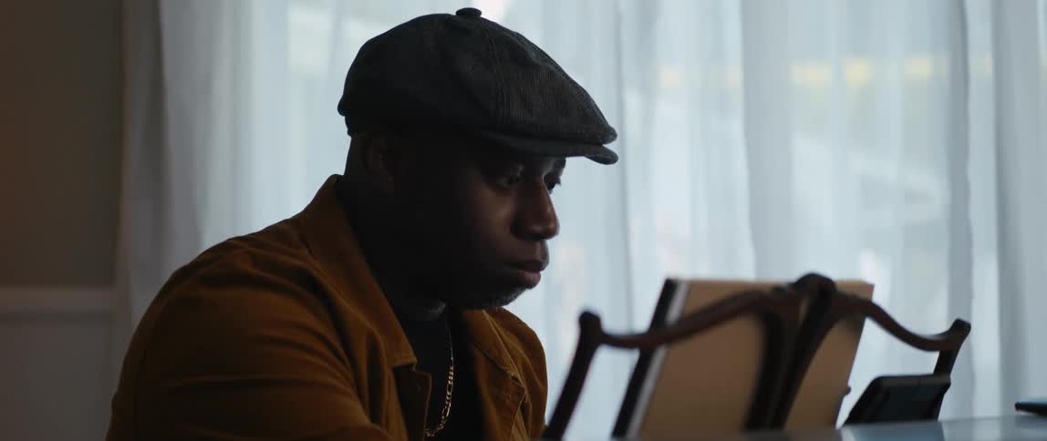 A man scrolls and taps on his phone to select music to play on the piano