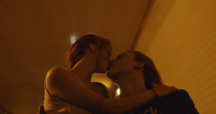 Young couple adventurously kissing on the back of a truck driving through a tunnel
