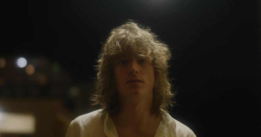 A male model posing for a portrait with a breeze blowing through his hair
