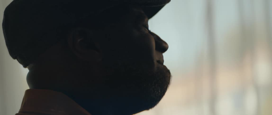 A man is wearing a hat and smiling happily