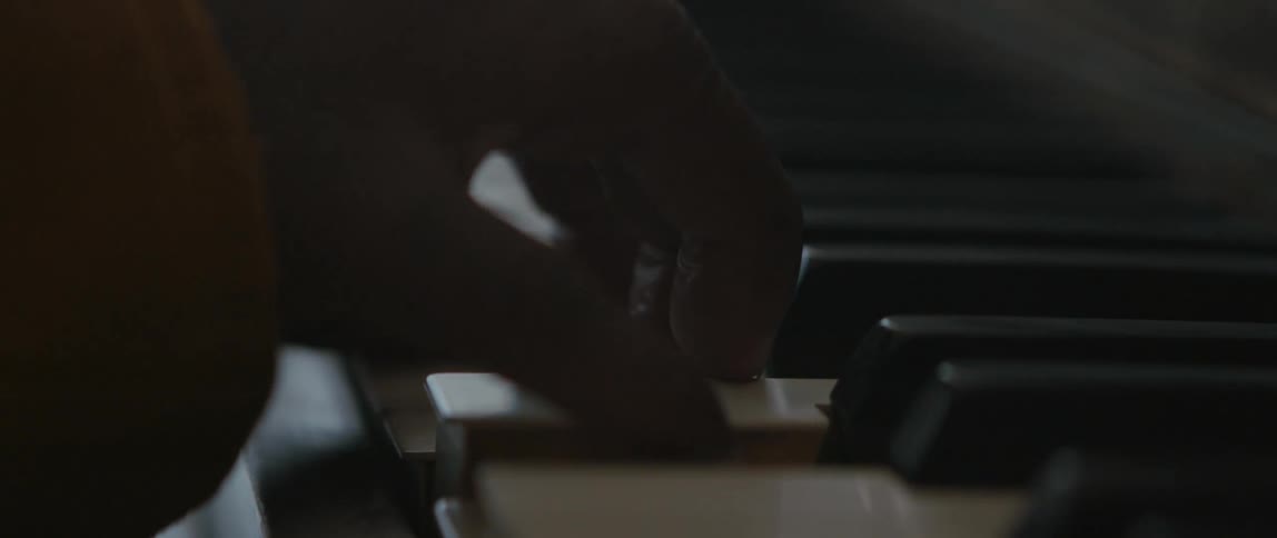 Close up of mans fingers playing on piano keys