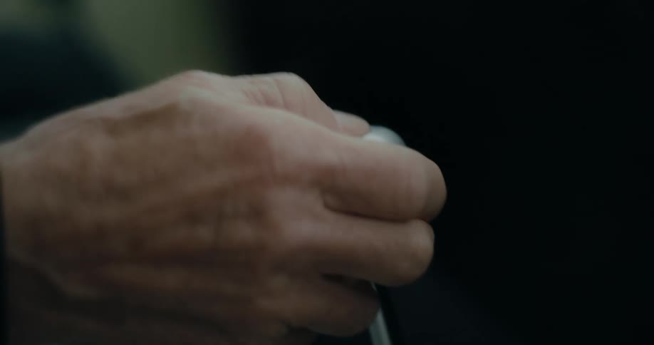 Hand of a man shifting down a vehicle gear stick