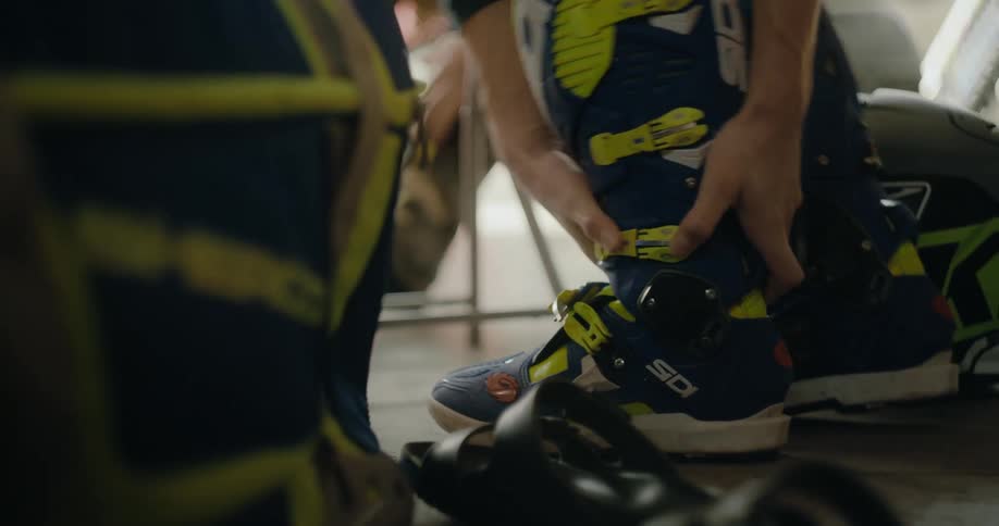 Men are sitting in a room and putting on shoes