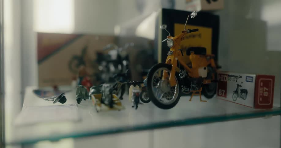 Toy motorcycles sitting on a glass shelf