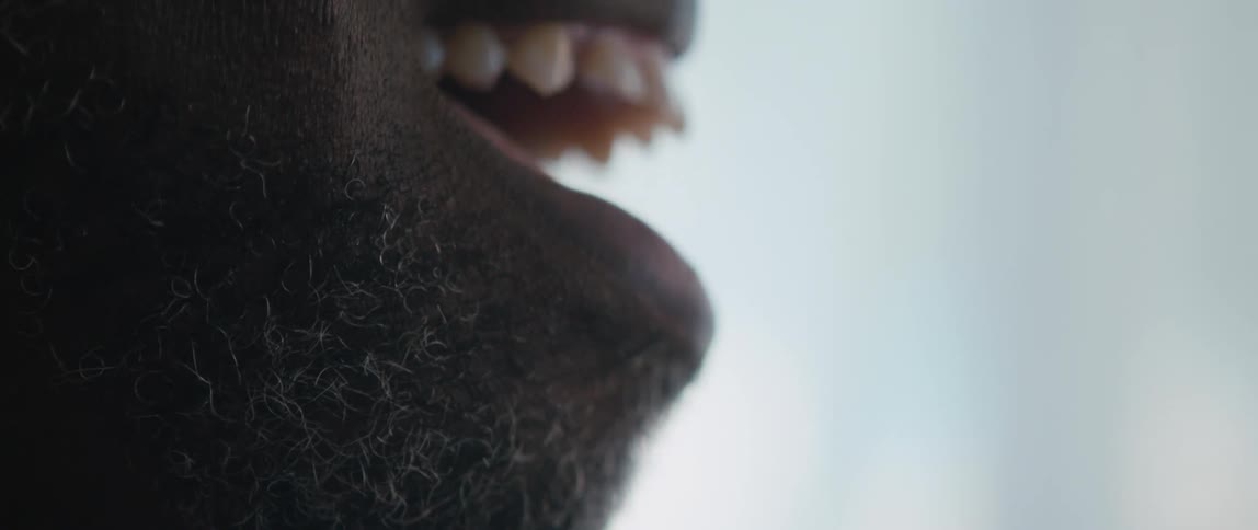A man is smiling and laughing indoors