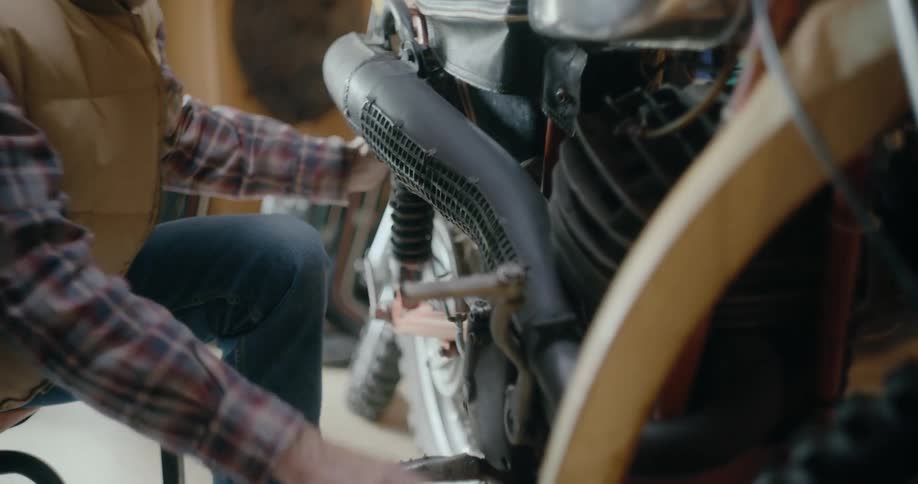 A man is fixing a motorcycle in his garage