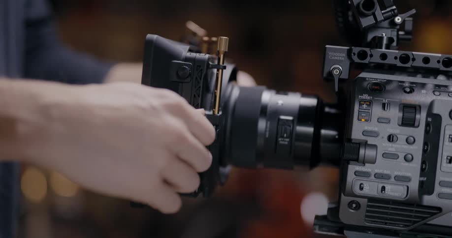 A person is putting together a photography camera