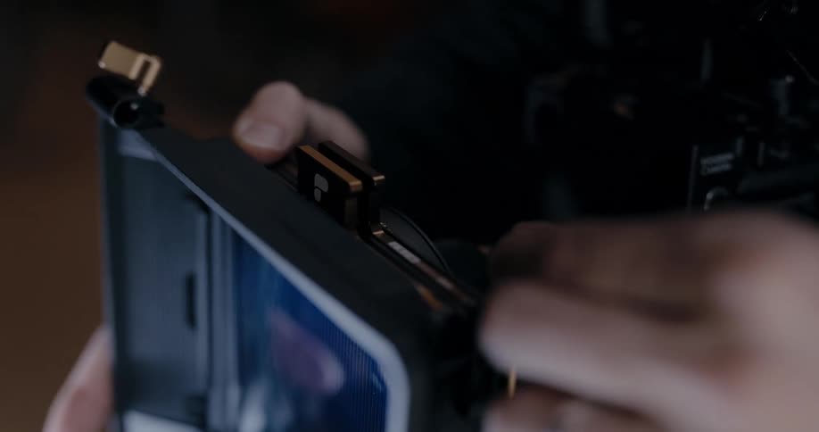 A photographer puts a lens on the camera