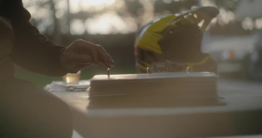 A man sitting outside looking at photographs of himself motorcycle racing