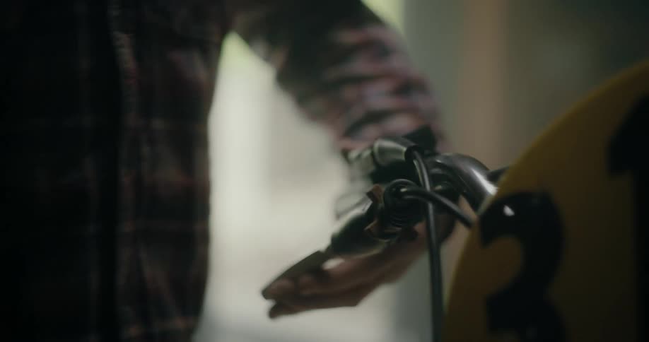 A man is checking the brakes on a bicycle in his garage
