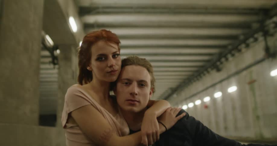 A couple hugs as they ride in a vehicle through a tunnel