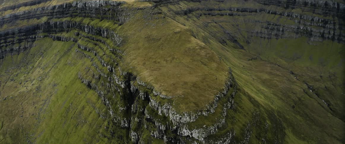 An aerial view of a grassy cliff in the wilderness