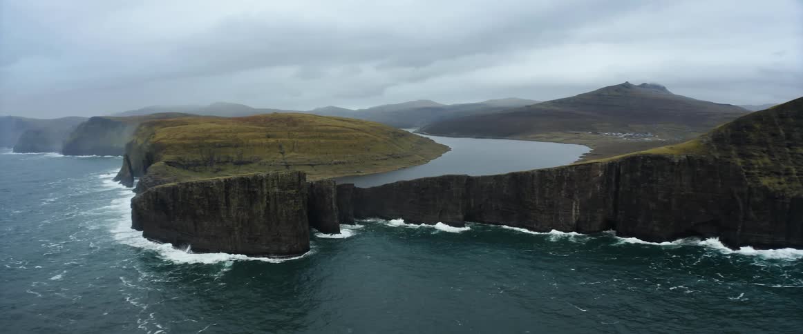 An aerial view of coastal land on a cloudy foggy day