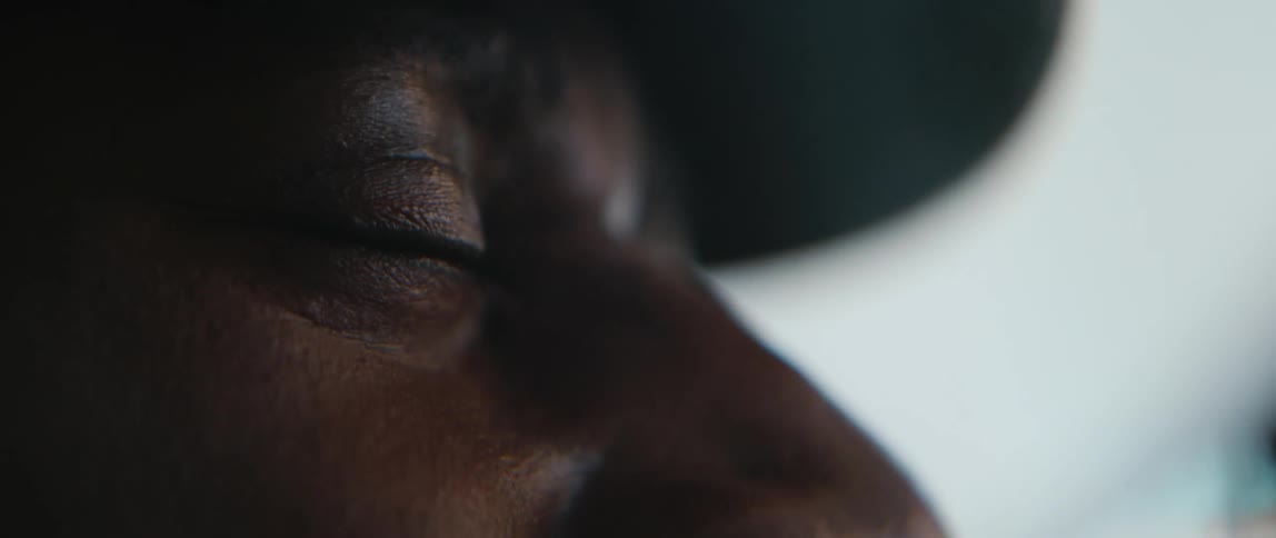 Closeup view of a man squinting his eyes and wearing a hat