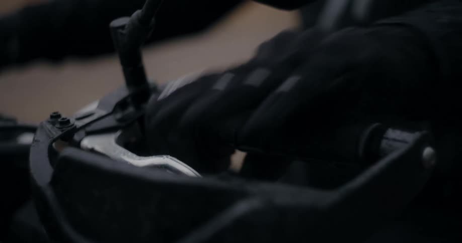 A person grabs the brake lever on a motorcycle