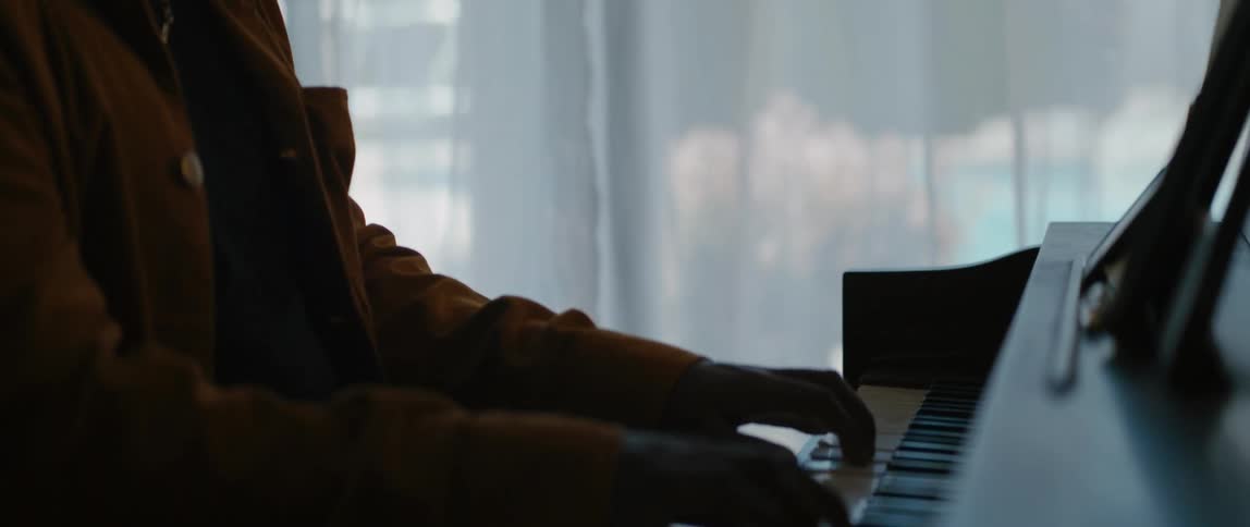 A man is playing the piano instrument indoors