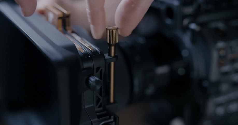 A woman turns a pin to adjust a piece of equipment
