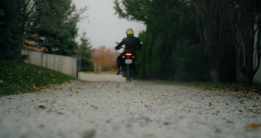 A person drives their motorcycle onto the street