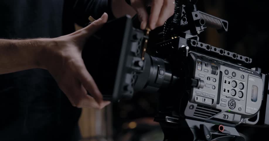 A person is putting together a photography camera