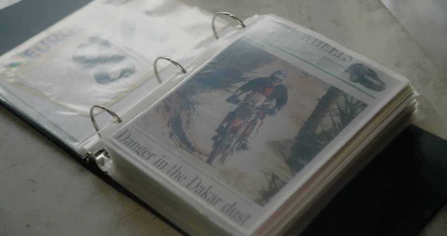 Person flips through binder related to motorcycles as another person walks by