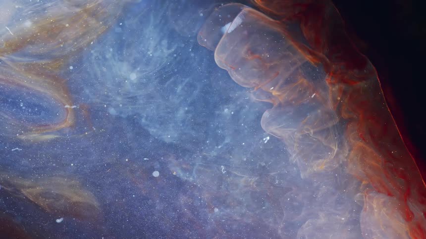 Red strands of deep dark glowing red and blue nebulous material against a dark background