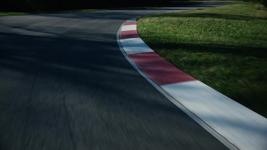 A vehicle turning a corner on an outdoor racetrack