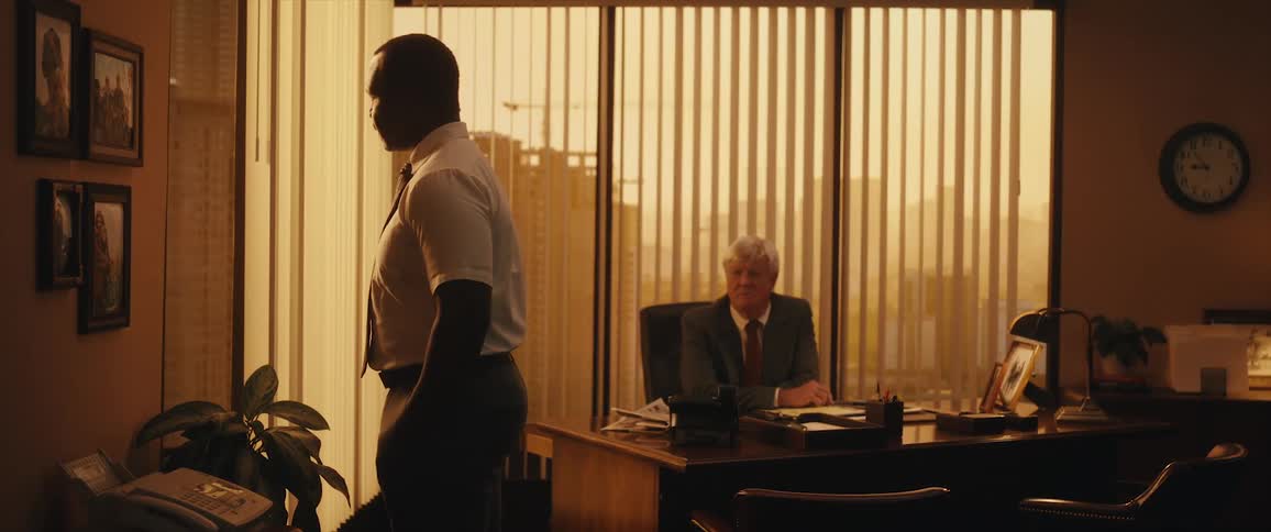 Two coworkers are talking to each other in an office