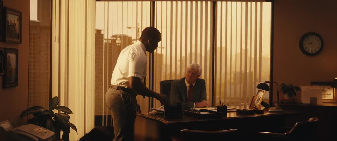 Two co workers are talking in the office in the middle of the day