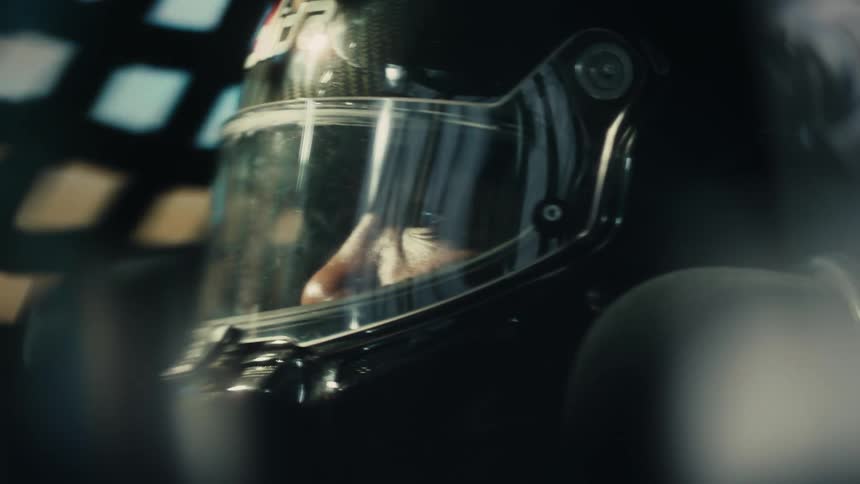 A person is in a race car and wearing a helmet