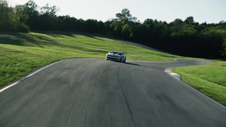 A car is driving on a road during the spring time