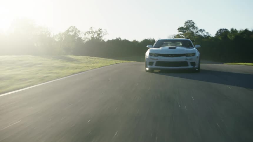 A car is driving on a race track during the spring time