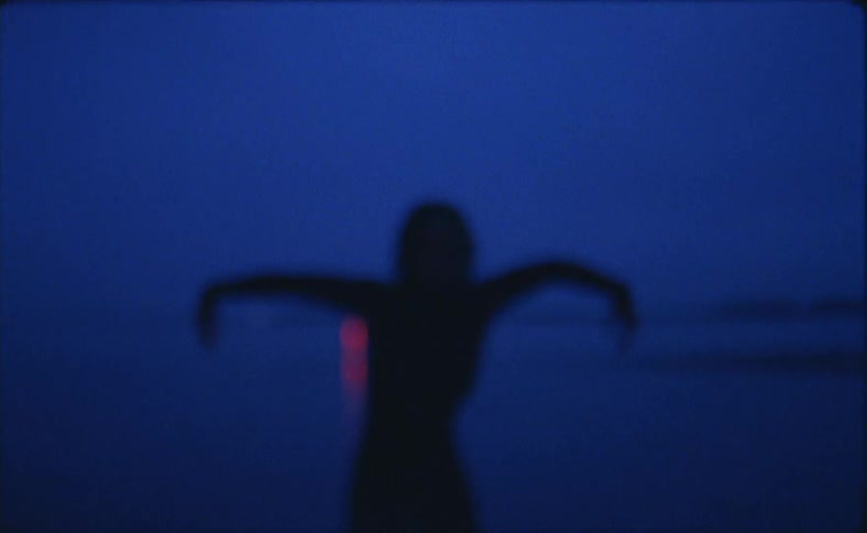 A silhouetted person waving their arms while dancing