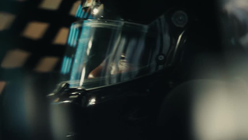 Race car pilot wearing a black crash helmet driving