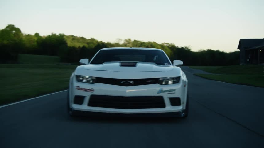 A car is driving on a road during the spring time