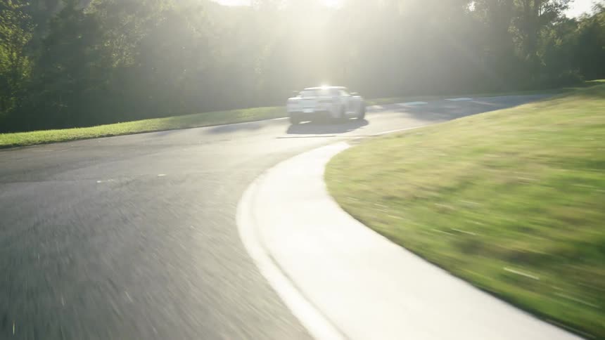 A car is racing on a track outdoors in spring
