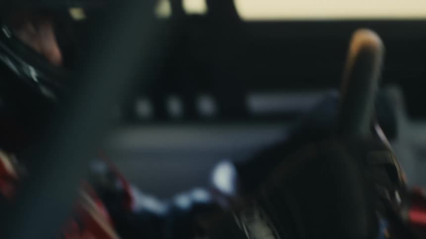 A man is driving a race car and wearing a helmet