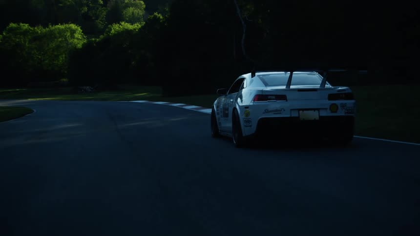 A person is driving a car on a race track during the spring