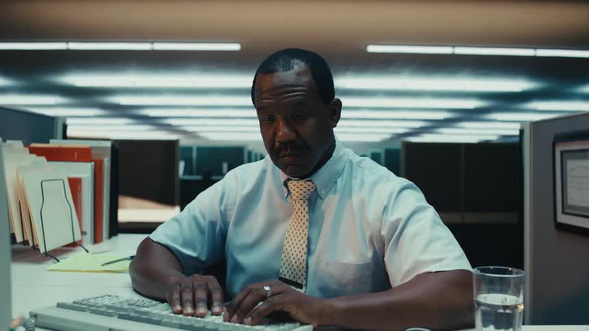 Bored anxious man working on computer in cubicle at work