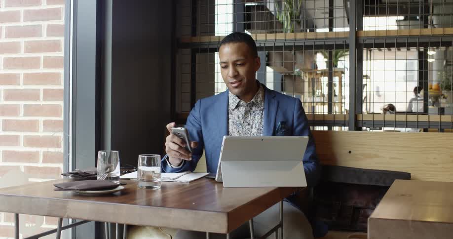 A man in a blue jacket works on a laptop