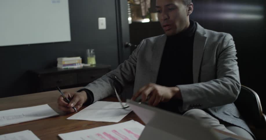 A man writes notes at his desk