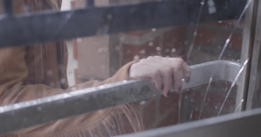 A person in a brown jacket walks into a building
