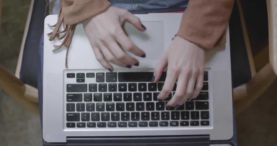 A person is typing on a laptop keyboard