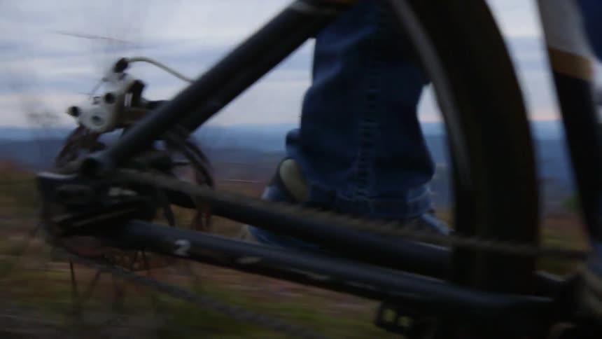 A man rides a mountain bike down a rough trail