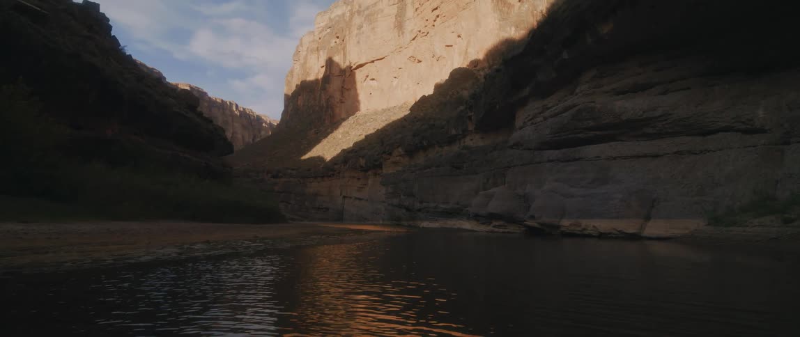 A view of a canyon from a river at the base