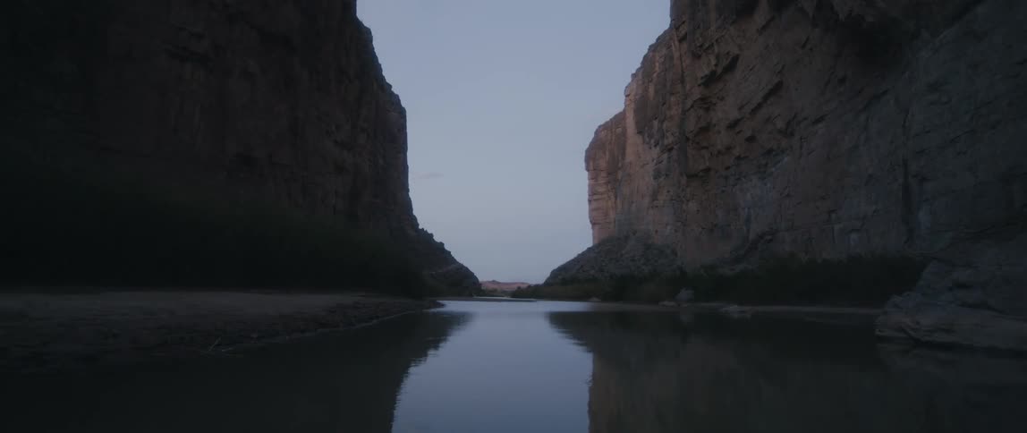 A stream along the floor of a canyon in the evening