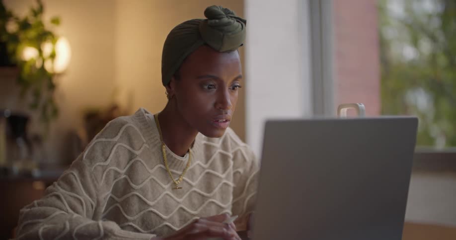 Young woman sitting at a table working on a laptop from home