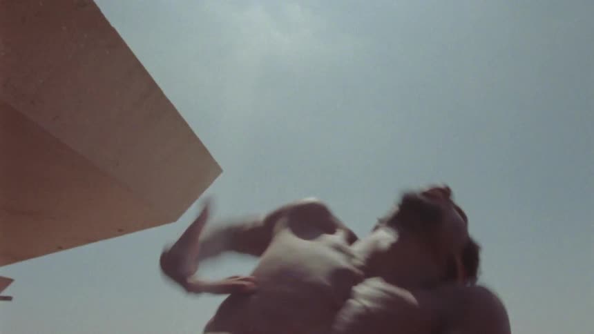 Shirtless male dancer performing some strong dance moves outdoors on a sunny day