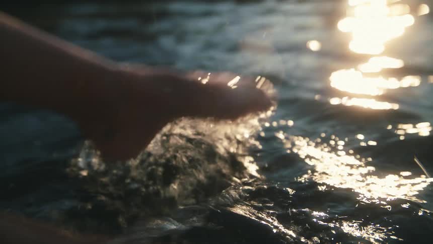 Feet splashing in a lake in the summer time
