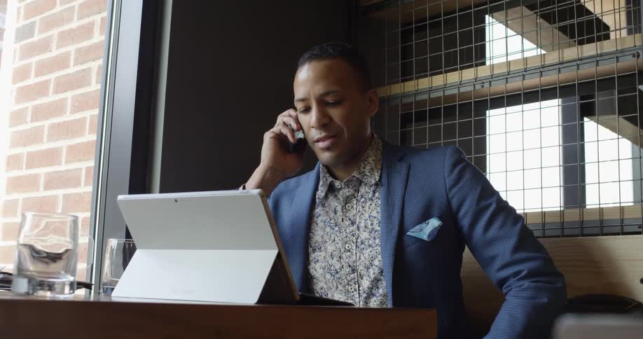A man in a blue jacket picks up his phone