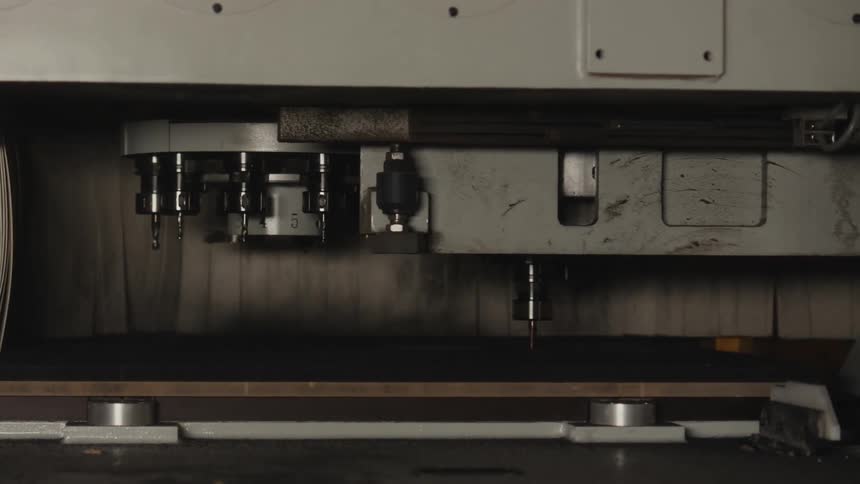 A machine in a factory carves on wood